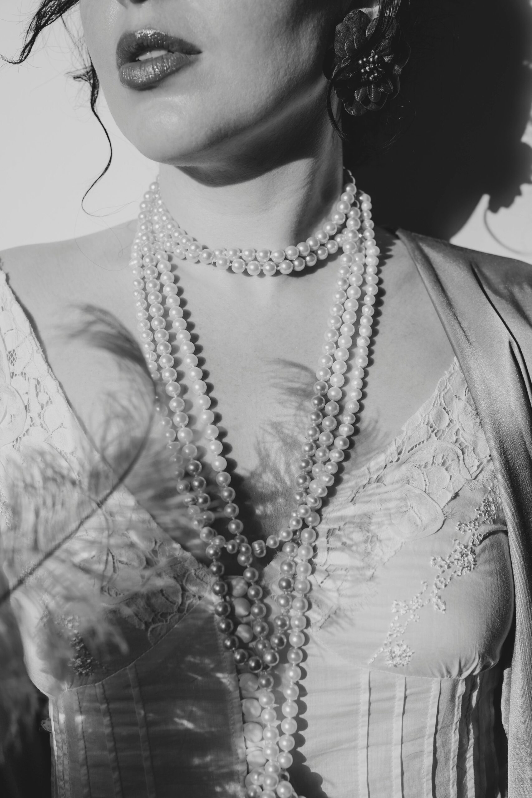 Stylish black and white portrait showcasing elegant pearls and fashion attire.